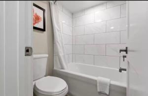 ein weißes Badezimmer mit Toilette und Badewanne in der Unterkunft Grande Cayman 1BR Penthouse Patio Oceanfront Views in Myrtle Beach