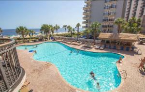 ein großer Swimmingpool mit Menschen in der Nähe eines Gebäudes in der Unterkunft Grande Cayman 1BR Penthouse Patio Oceanfront Views in Myrtle Beach