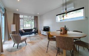 a living room with a table and chairs and a couch at 2 Bedroom Amazing Home In Hellendoorn in Hellendoorn