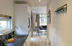 a kitchen with a sink and a living room at 2 Bedroom Amazing Home In Hellendoorn in Hellendoorn +14 photos