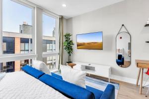 费城Floor To Ceiling Windows- Bridge Views - Studio的客厅配有蓝色的沙发和壁挂式冲浪板