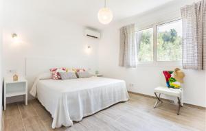Un dormitorio blanco con una cama y una silla. en Oasis Can Picafort, en Can Picafort 20 fotos más