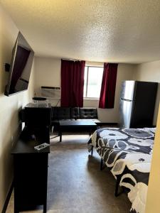 a hotel room with a bed and a couch at The Suite Inn in Rapid City +5 photos