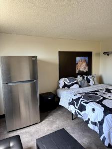 a bedroom with a bed and a refrigerator at The Suite Inn in Rapid City