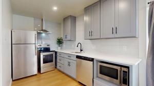 a kitchen with white cabinets and a white refrigerator at Ocean's Edge Luxury Rentals in Ocean City