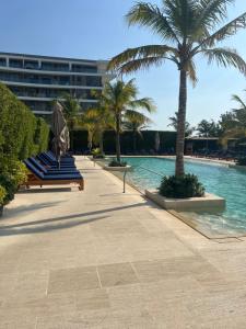 una fila de tumbonas azules junto a una piscina en Cartagena Serena del mar Morros IO, en Cartagena de Indias