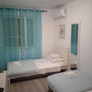 Dos camas en un dormitorio con cortinas azules. en Quite Bedroom for 2, in center of Split, overnight stay, en Split