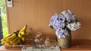 a table with bananas and a vase of flowers at Lilys Stone Garden Bungalow in Tram de Dak Mil