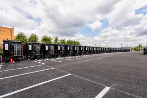 a long line of train cars parked in a parking lot at HOTEL R9 The Yard Mokaaramachi in Mooka