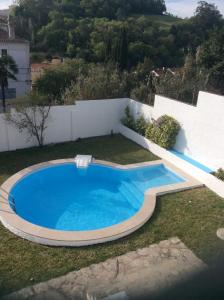 a swimming pool in the yard of a house at Casa Dos Oliva in Alcobaça