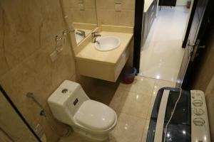 a bathroom with a white toilet and a sink at Dar Hashim Hotel Suites - Al Sahafa in Riyadh