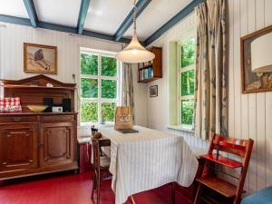 Una cocina con mesa y sillas y ventanas. en Holiday Home in Vrouwenpolder near Beach, en Vrouwenpolder