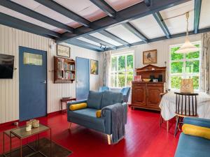 Una sala de estar con un sofá azul y una mesa. en Holiday Home in Vrouwenpolder near Beach, en Vrouwenpolder