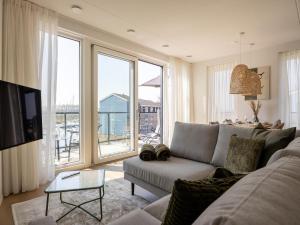 a living room with a couch and a large window at Apartment in Kortgene with Harbor View in Kortgene