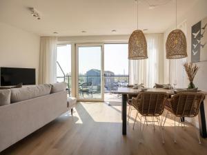 a living room with a couch and a table and chairs at Apartment in Kortgene with Harbor View in Kortgene