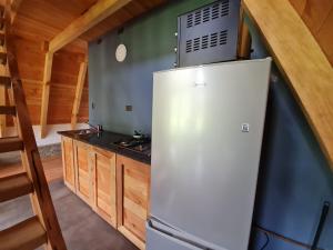 a kitchen with a refrigerator and a stove at Cabaña Alpina Los Treiles in Panguipulli +5 photos