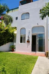 une maison blanche avec une grande porte vitrée dans l'établissement Casa Colibri Teques, à Tequesquitengo