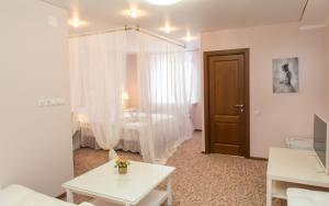 uma sala de estar com uma cama, uma mesa e uma porta em Dva Kryla Inn em Yaroslavl