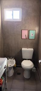 a bathroom with a white toilet and a sink at Cómodo y moderno departamento con cochera en Mendoza in Las Heras