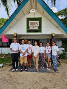 um grupo de pessoas em pé em frente a um prédio em DK2 Resort - Hidden Natural Beach Spot - Direct Tours & Fast Internet em El Nido