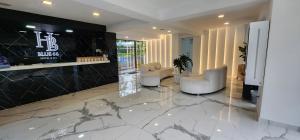 Eine Lobby mit zwei weißen Stühlen und einem Marmorboden in der Unterkunft Hotel Blue 66 in Cali + 85 Fotos