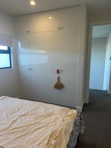 a bedroom with a bed and a large white cabinet at Deva house in Box Hill