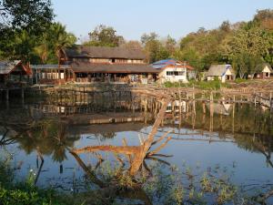 a village with houses and a body of water at Muangkham Peaceandlove Farm in Ban Doi Hang