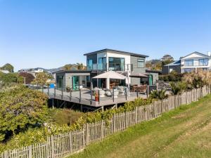une maison avec une terrasse et une clôture dans l'établissement Island Views - Waihi Beach Holiday Home, à Waihi Beach