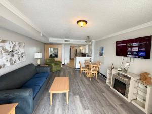 默特尔比奇Paradise Resort的客厅里有一张蓝色的沙发和一张桌子