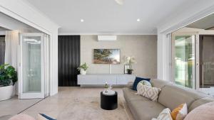 a living room with a couch and a table at Pura Villa - Tropical Luxury Living in Palm Cove