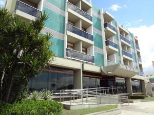 um edifício de apartamentos com uma fachada azul e palmeiras em Hotel Sol da Praia em Vitória