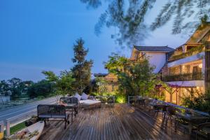 a deck with chairs and tables on a house at Munwood Dali Lanqing Designer Hotel in Dali Ancient Town