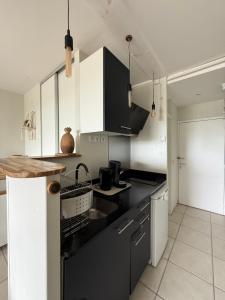 a kitchen with black counters and white cabinets at Tropi-k in Le Gosier