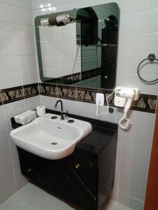 a bathroom with a sink and a mirror at Suíte no Morumbi in Sao Paulo