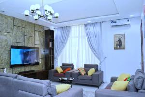 a living room with couches and a flat screen tv at Jay Homes in Lagos