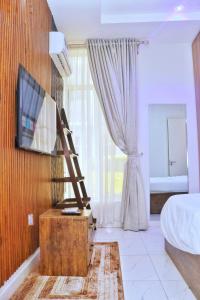 a bedroom with a bed and a tv and a ladder at Jay Homes in Lagos