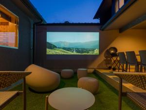 a room with a projection screen with chairs and tables at Rakuten STAY VILLA Hakone Togendai in Hakone