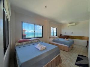 a bedroom with two beds and a window at Casaroyal Beachfront Siquijor in Siquijor