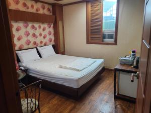 a small bedroom with a bed and a mirror at Gwangju M Motel in Gwangju +7 photos