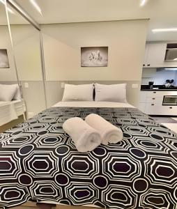 a bedroom with a bed with two white towels on it at *ExtraOdiNáriO, Super Confort. Lazer com piscina. in Curitiba