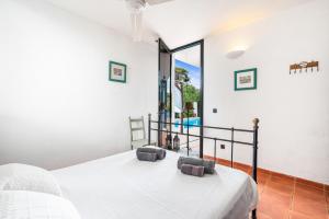 ein Schlafzimmer mit einem Bett und einem großen Fenster in der Unterkunft ANANA Binisafua in Binisafua