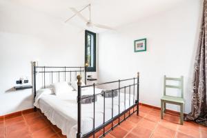 ein Schlafzimmer mit einem Bett und einem Stuhl darin in der Unterkunft ANANA Binisafua in Binisafua + 30 Fotos