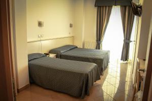 a room with two beds and a window at Hotel Holiday in San Benedetto del Tronto