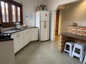 a kitchen with a white refrigerator in a room at Recanto Pau Brasil in Sete Lagoas