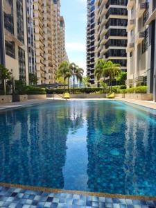 a swimming pool in the middle of two tall buildings at Stylish New Studio at McKinley Hill BGC Free Netflix in Manila