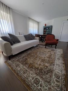 a living room with a white couch and a rug at Apúlia Beach Avenue in Apúlia