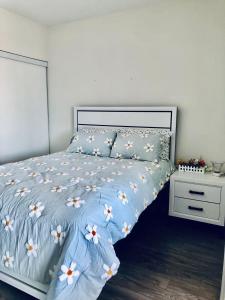 ein Bett mit einer blauen Bettdecke mit Blumen darauf in der Unterkunft Luxury Lake and CN Tower View 1 plus 1 in Toronto + 20 Fotos