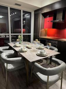 eine Küche mit einem Holztisch mit Stühlen und Weingläsern in der Unterkunft Luxury Lake and CN Tower View 1 plus 1 in Toronto