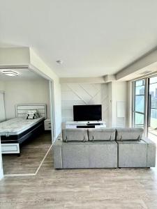ein Wohnzimmer mit Sofa und Flachbildfernseher in der Unterkunft Luxury Lake and CN Tower View 1 plus 1 in Toronto