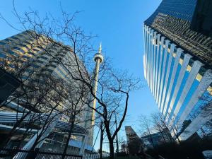 ein hoher Turm mitten in einer Stadt mit Gebäuden in der Unterkunft Luxury Lake and CN Tower View 1 plus 1 in Toronto